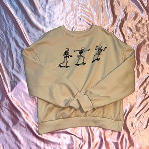 Beige sweatshirt with skateboarding skeletons